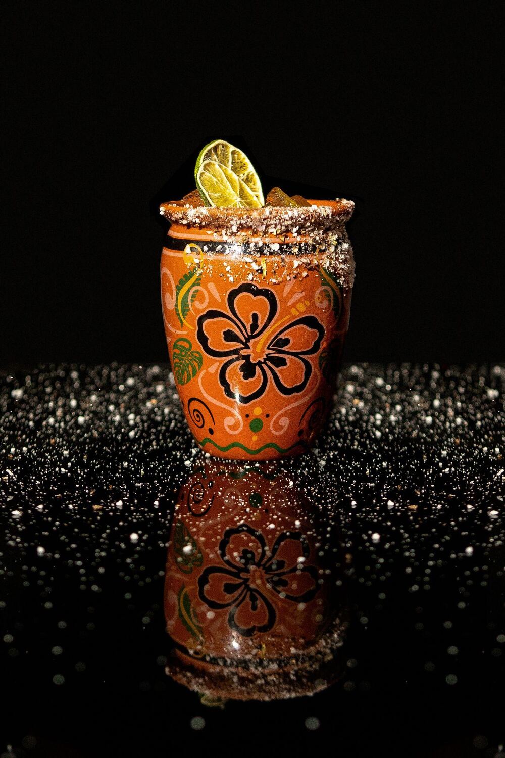 Signature cocktail on a black glitter surface